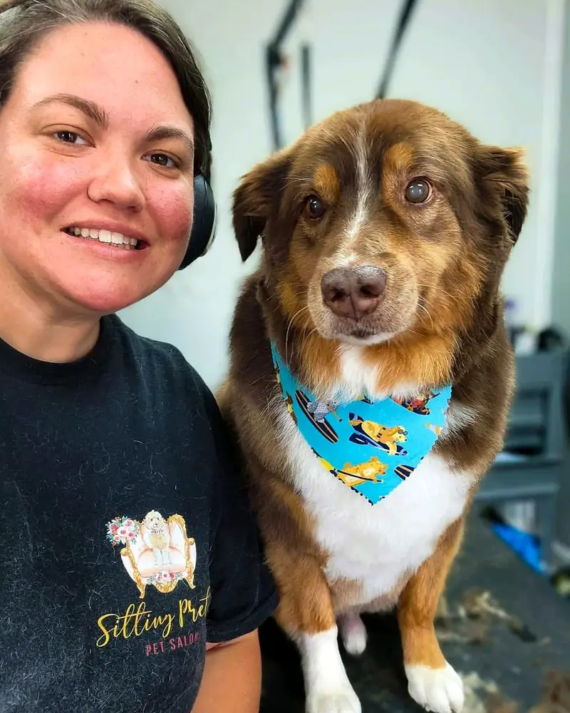 Taylor Benton, owner of Sitting Pretty Pet Salon, with an Australian shepherd